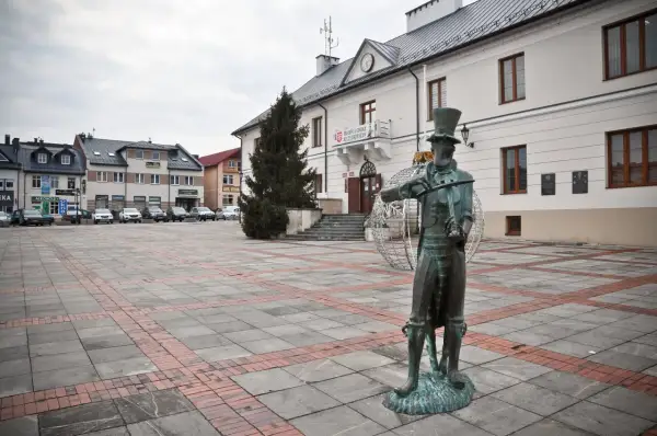 Pomnik chrząszcza w Szczebrzeszynie, jedna z głównych atrakcji miasta, na tle ratusza i placu.